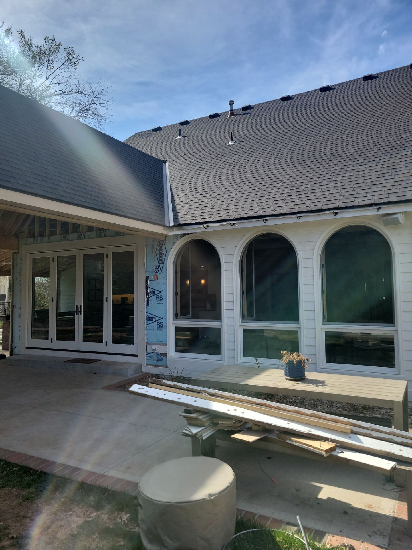 New white-framed arched windows and folding patio doors on a home addition in Overland Park, KS