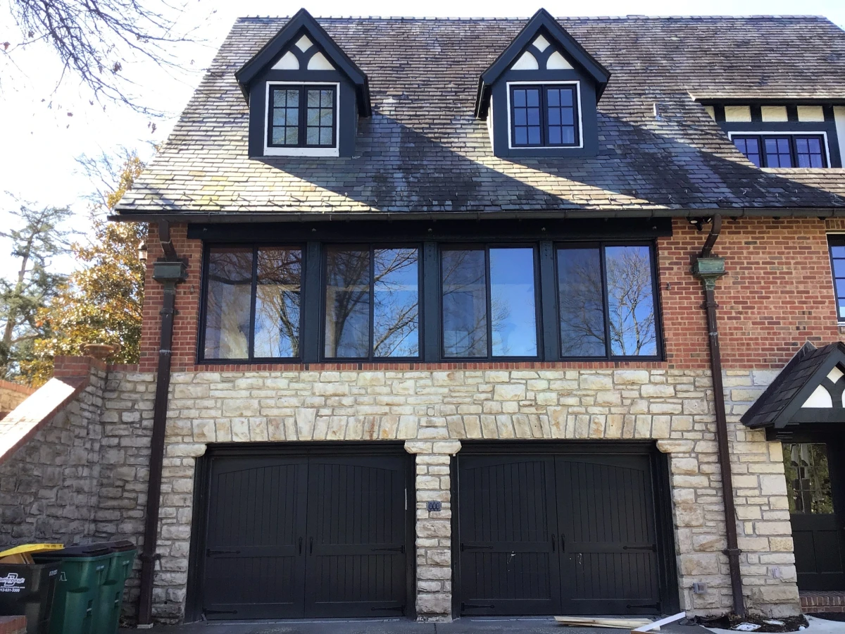 Two-story brick home in Loch Lloyd, MO with dormer windows and dark garage doors