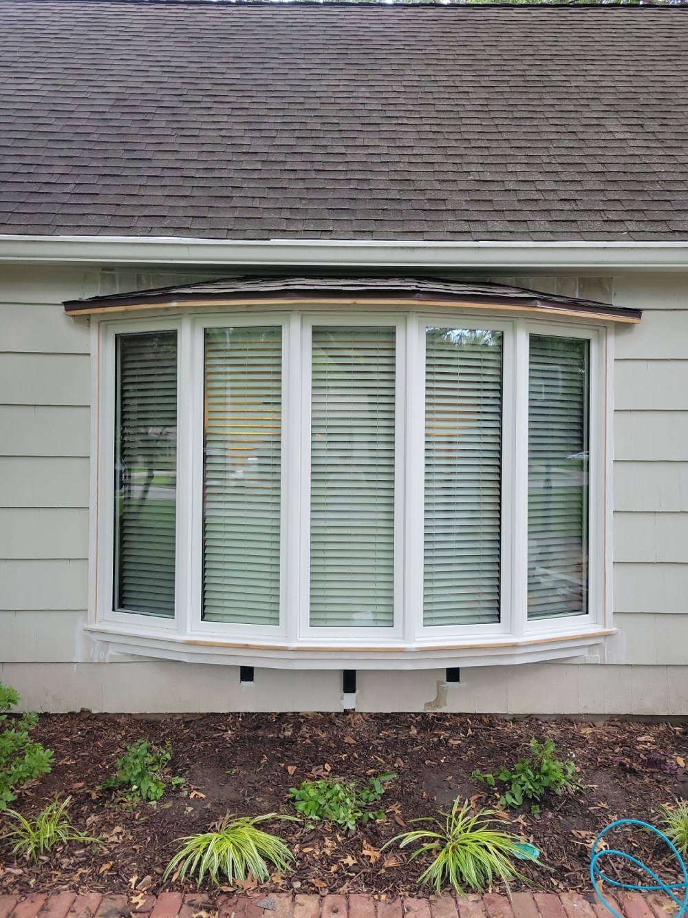 Newly installed five-panel bay window with shingled roof on a home exterior in Leawood, KS