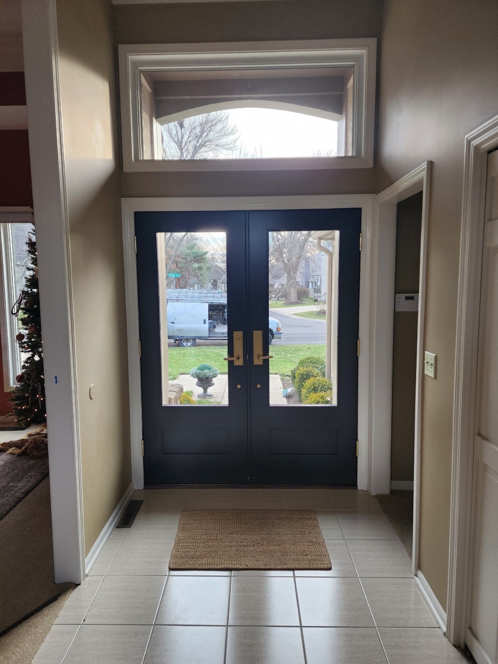 Interior view of new navy blue double front entry doors with glass panels and matching transom window, Leawood, KS home