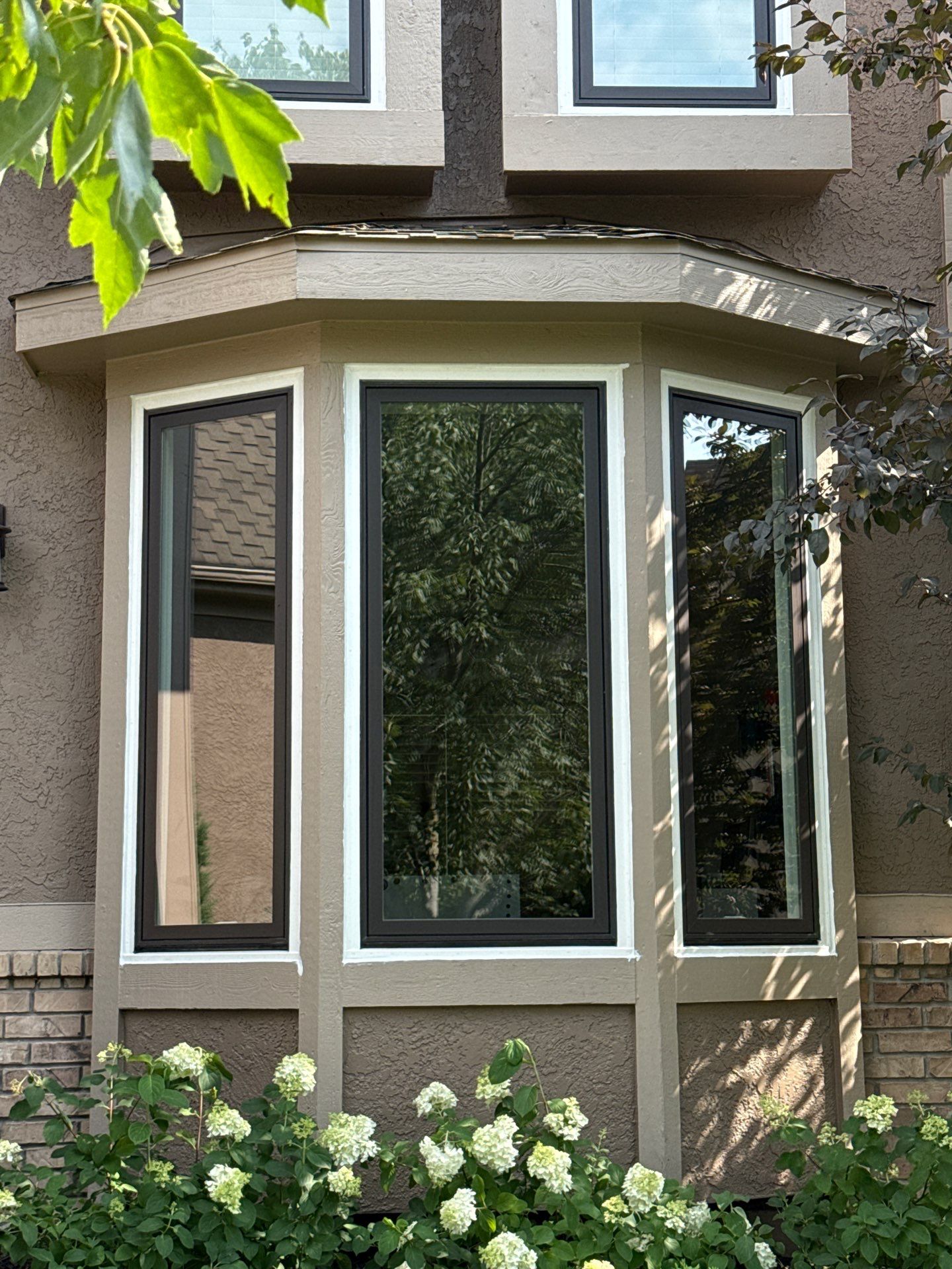 New black-framed bay window with casement panels on a stucco home exterior in Shawnee, KS